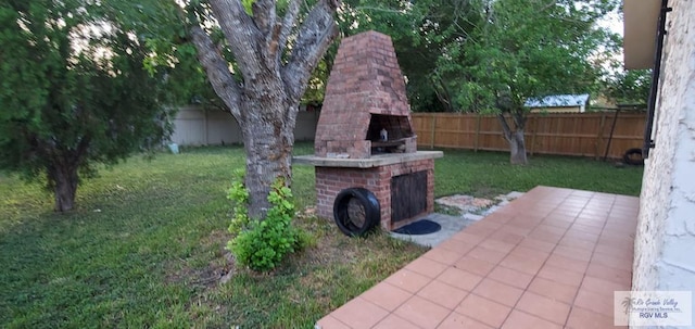 4853 Paseo Del Rey Dr, Brownsville, TX 78526 - view of yard featuring an outdoor brick fireplace and a patio area