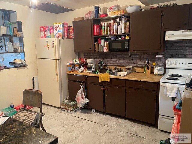 44 N St, Brownsville, TX 78521 - kitchen featuring sink, white appliances, dark brown cabinets, and decorative backsplash