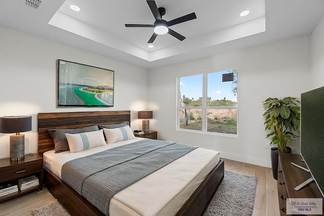 1421 6th St, Harlingen, TX 78550 - bedroom with recessed lighting, light wood finished floors, a raised ceiling, baseboards, and a ceiling fan