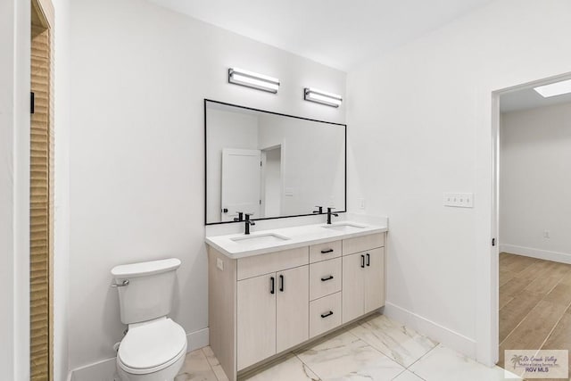 1421 6th St, Harlingen, TX 78550 - full bath with baseboards, double vanity, toilet, and marble finish floors