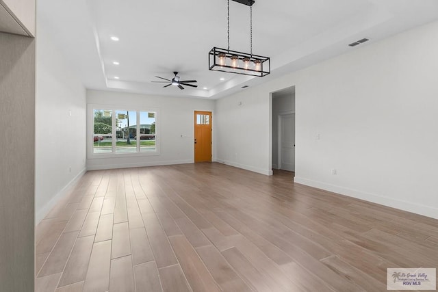 1421 6th St, Harlingen, TX 78550 - unfurnished living room featuring a raised ceiling, ceiling fan, light wood-type flooring, recessed lighting, and baseboards