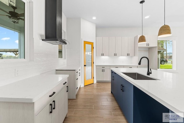 1421 6th St, Harlingen, TX 78550 - kitchen featuring a sink, wall chimney range hood, decorative backsplash, ceiling fan, and pendant lighting