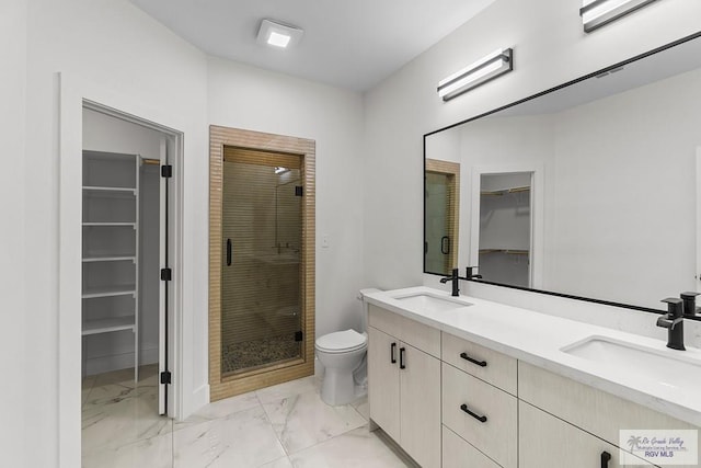 1421 6th St, Harlingen, TX 78550 - bathroom featuring a walk in closet, marble look tile flooring, double vanity, a stall shower, and toilet