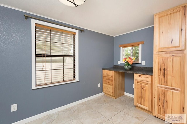 kitchen featuring light brown cabinets, built in desk, and crown molding