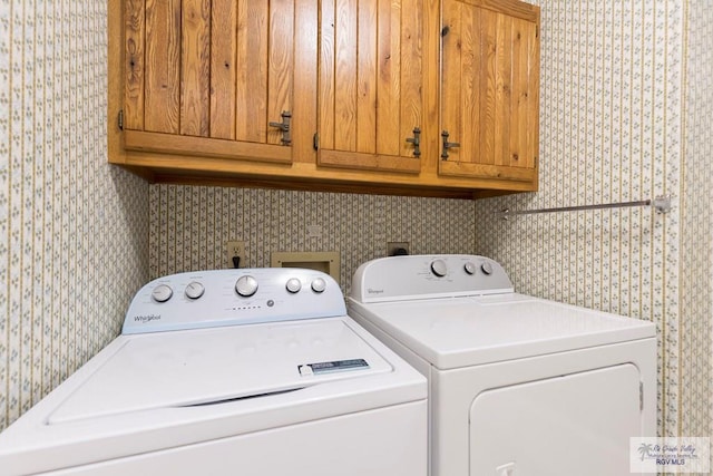 laundry room featuring washer and clothes dryer and cabinets