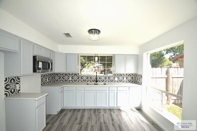 kitchen with tasteful backsplash, sink, and dark wood-type flooring