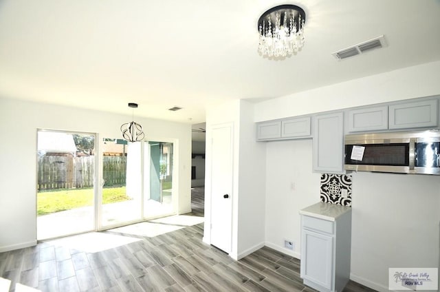 kitchen featuring hardwood / wood-style floors, gray cabinets, and a chandelier