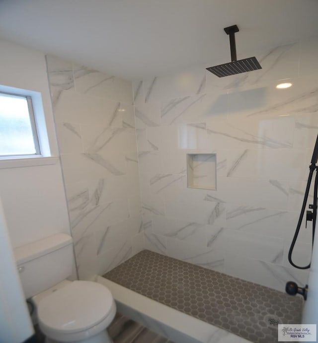 bathroom featuring toilet and tiled shower