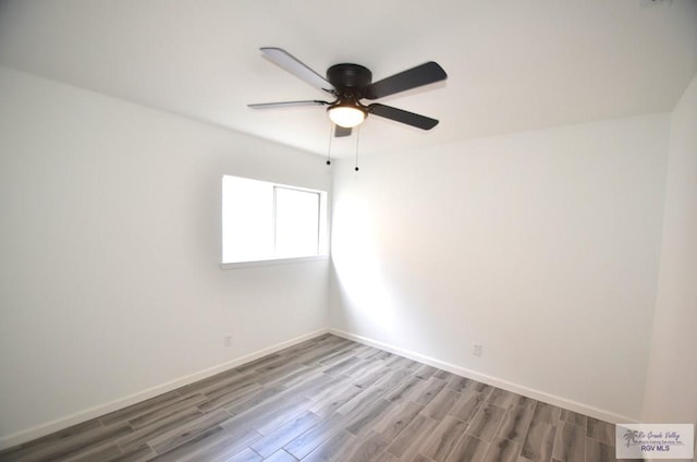 spare room with hardwood / wood-style floors and ceiling fan