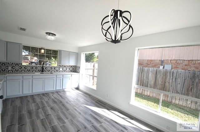 kitchen featuring dark hardwood / wood-style flooring, sink, a wealth of natural light, and a chandelier