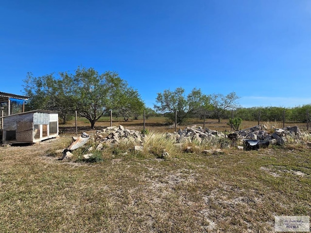 view of yard with a rural view and an outdoor structure