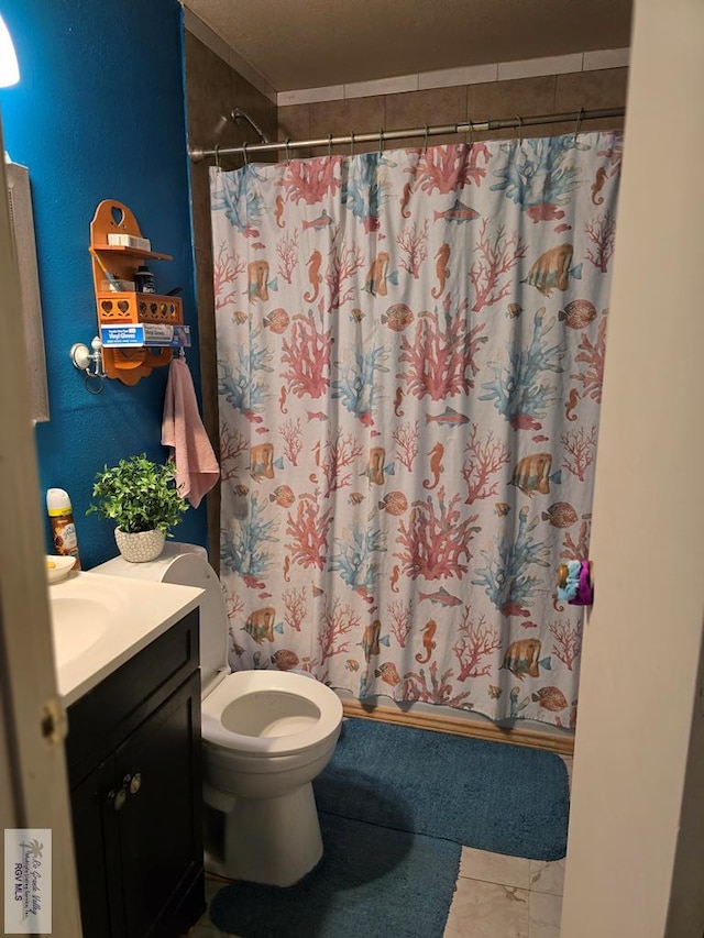 bathroom with vanity, curtained shower, and toilet