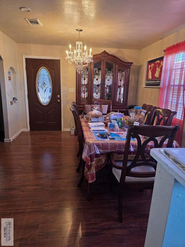 dining room featuring dark hardwood / wood-style flooring and a notable chandelier