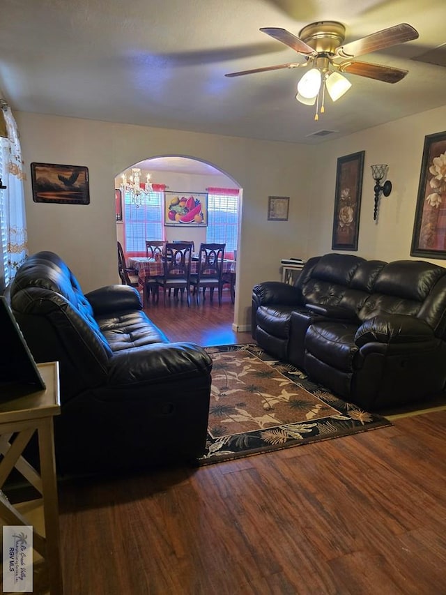 living room featuring dark hardwood / wood-style flooring and ceiling fan with notable chandelier