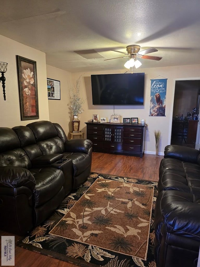 living room featuring wood-type flooring, a textured ceiling, and ceiling fan