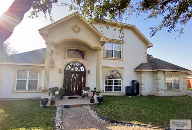 34 Picadilly Cir, Brownsville, TX 78526 - view of exterior entry with a shingled roof, french doors, a yard, and stucco siding