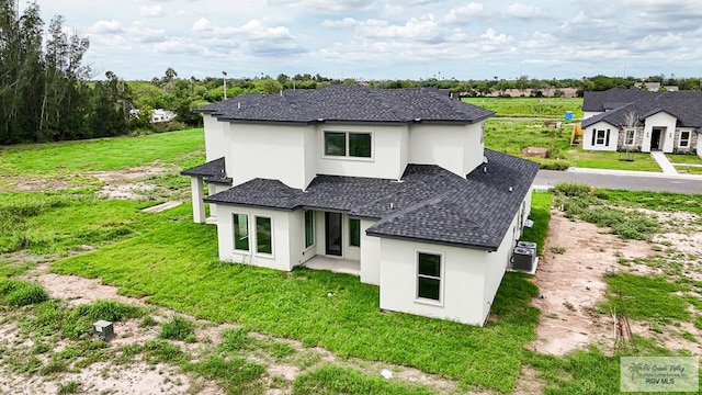 rear view of property with a yard and central AC unit