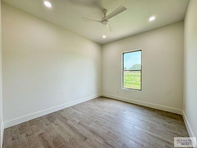 spare room with light hardwood / wood-style flooring and ceiling fan