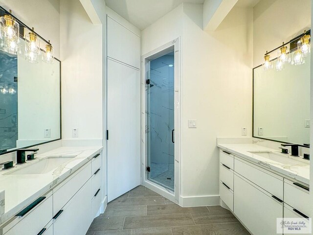 bathroom with a shower with door, vanity, and hardwood / wood-style flooring