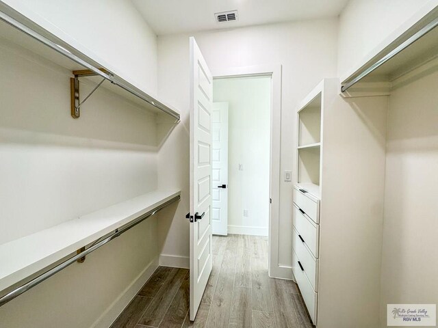 spacious closet with light hardwood / wood-style flooring