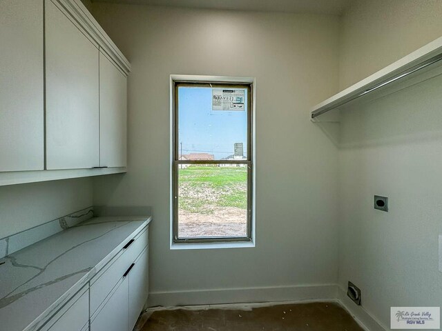 washroom featuring hookup for an electric dryer and cabinets