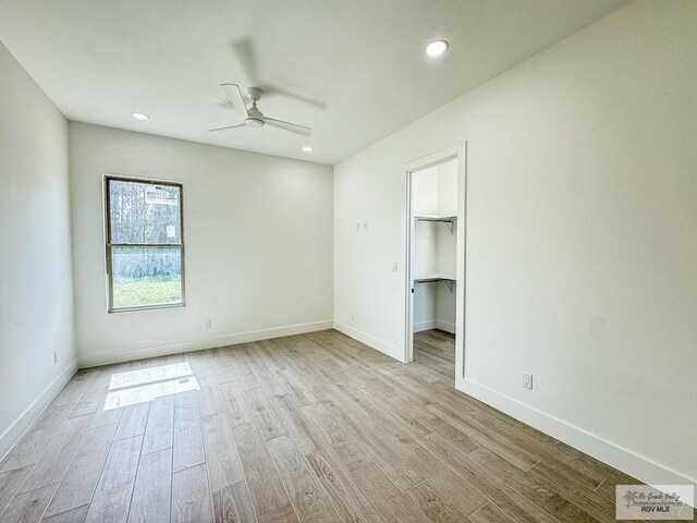 empty room featuring ceiling fan and light hardwood / wood-style floors