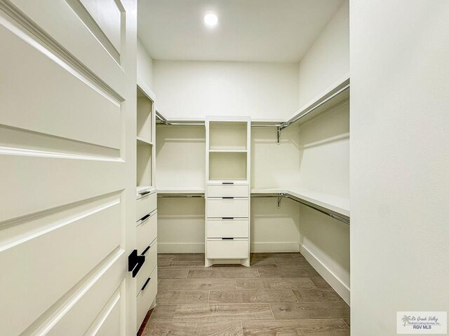 walk in closet with light wood-type flooring