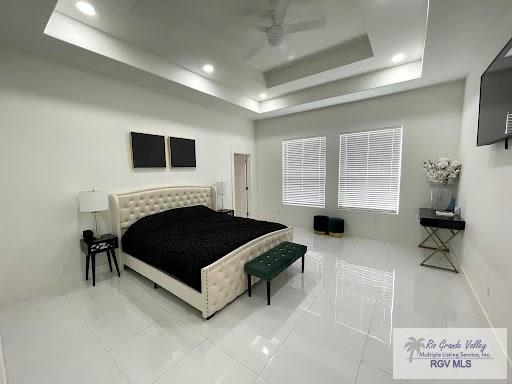 bedroom with a raised ceiling and ceiling fan