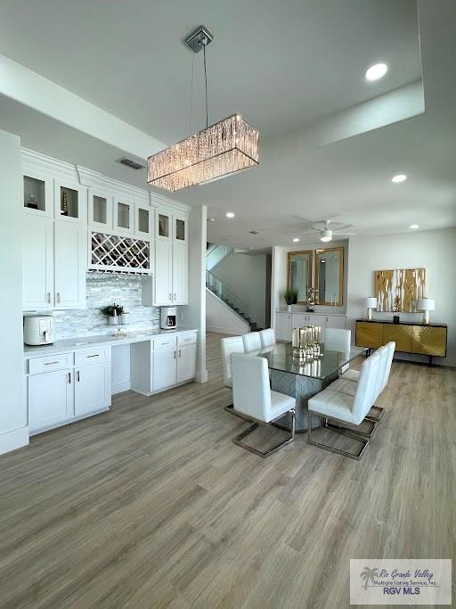 unfurnished dining area featuring ceiling fan and light hardwood / wood-style floors