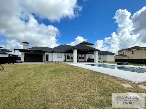 back of house featuring a fenced in pool, a yard, and a patio