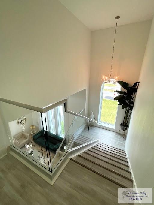 stairway featuring a notable chandelier and hardwood / wood-style flooring