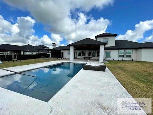 view of swimming pool with a lawn and a patio area