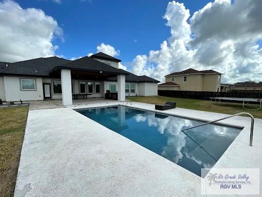 view of pool featuring a yard, a patio, and a trampoline