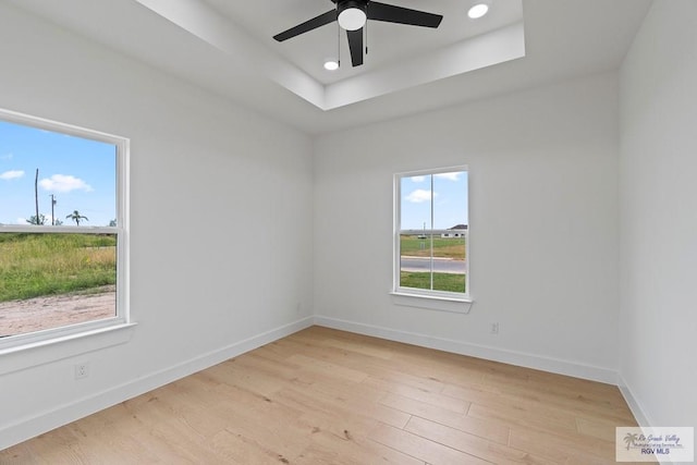 29002 Reynolds Dr # 18, La Feria, TX 78559 - spare room with light wood-style floors, ceiling fan, recessed lighting, and a tray ceiling