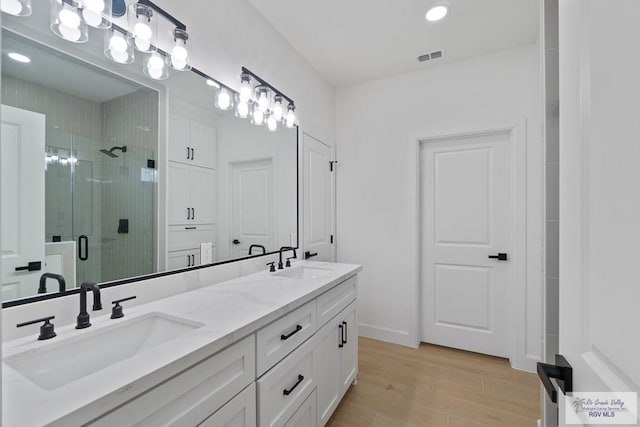 29002 Reynolds Dr # 18, La Feria, TX 78559 - bathroom with double vanity, a shower stall, wood finished floors, and recessed lighting