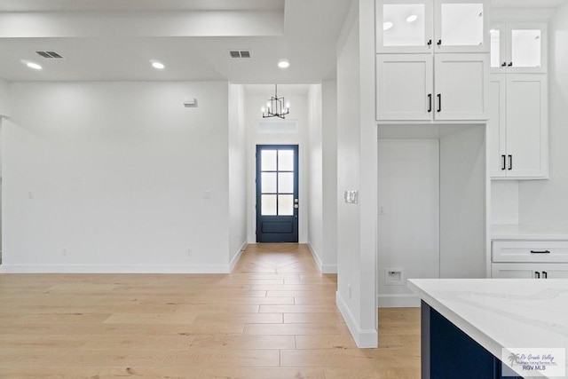 29002 Reynolds Dr # 18, La Feria, TX 78559 - kitchen with light wood-style floors, white cabinetry, light stone countertops, a chandelier, and recessed lighting