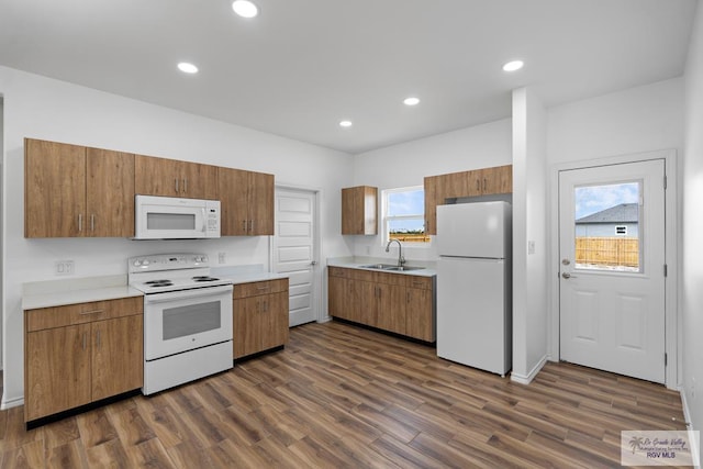 kitchen with dark hardwood / wood-style flooring, white appliances, sink, and a wealth of natural light