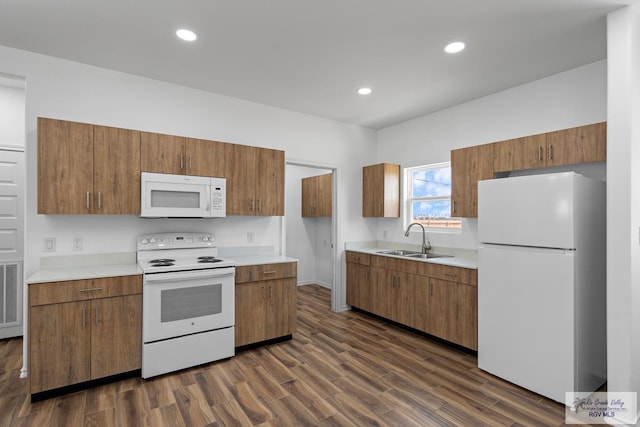 kitchen featuring white appliances, sink, and dark wood-type flooring