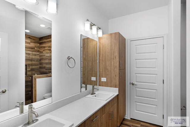 bathroom with wood-type flooring, vanity, toilet, and wooden walls