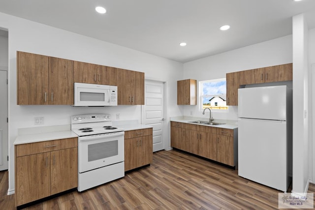 kitchen featuring sink, dark wood-type flooring, and white appliances