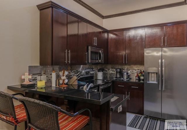 kitchen with a breakfast bar area, backsplash, dark brown cabinets, and appliances with stainless steel finishes