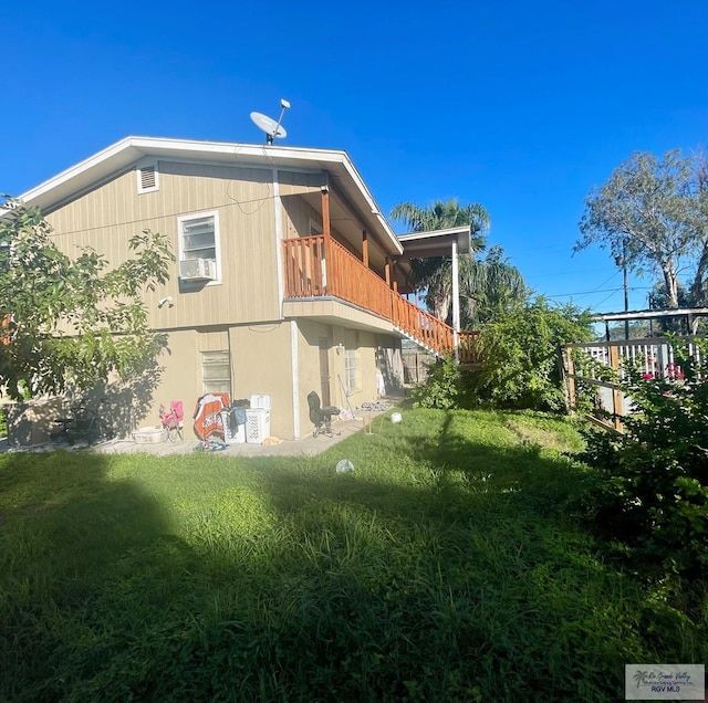 view of home's exterior with a balcony and a lawn