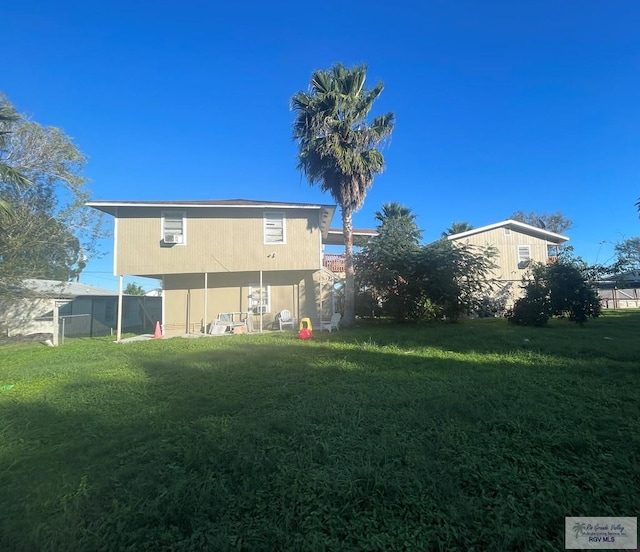 rear view of property featuring a lawn