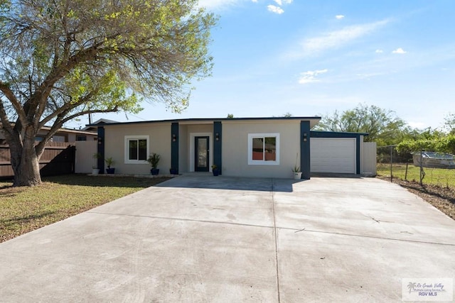 ranch-style home featuring a garage and a front lawn