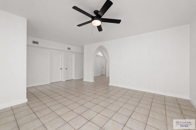 tiled spare room with ceiling fan