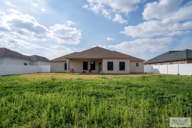 rear view of house featuring a yard