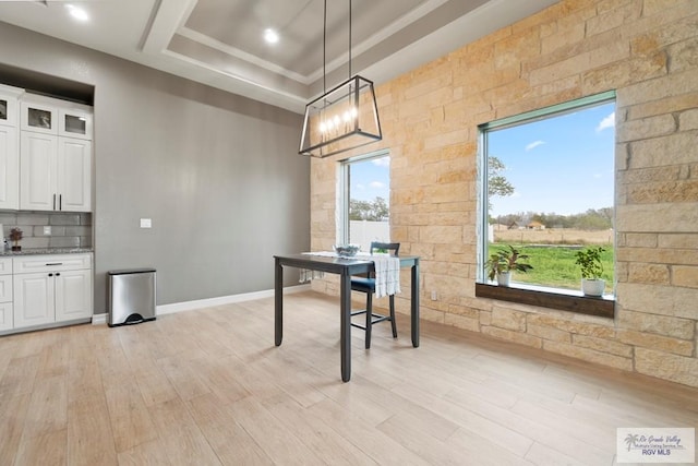 dining space featuring a tray ceiling and light hardwood / wood-style flooring