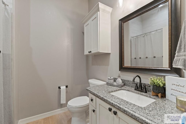 bathroom with hardwood / wood-style floors, vanity, curtained shower, and toilet