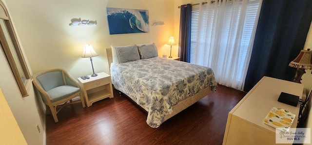 bedroom with dark hardwood / wood-style floors and multiple windows