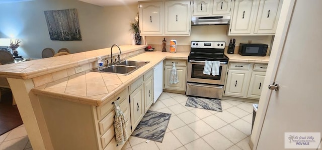 kitchen featuring kitchen peninsula, tile counters, stainless steel range with electric cooktop, and sink